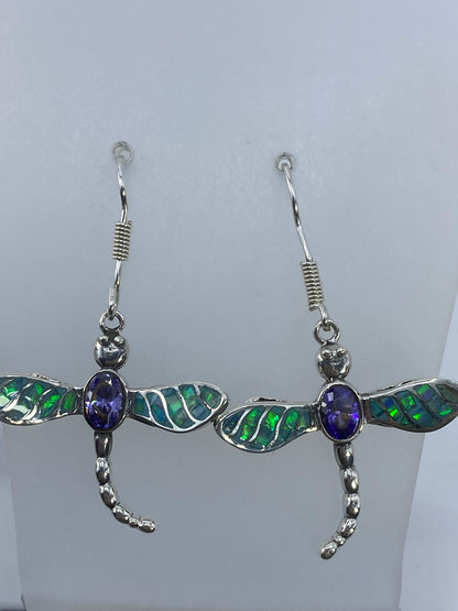 Par de aretes de plata en forma de libélula con ópalo de fuego verde olivo y circonia morada colgando