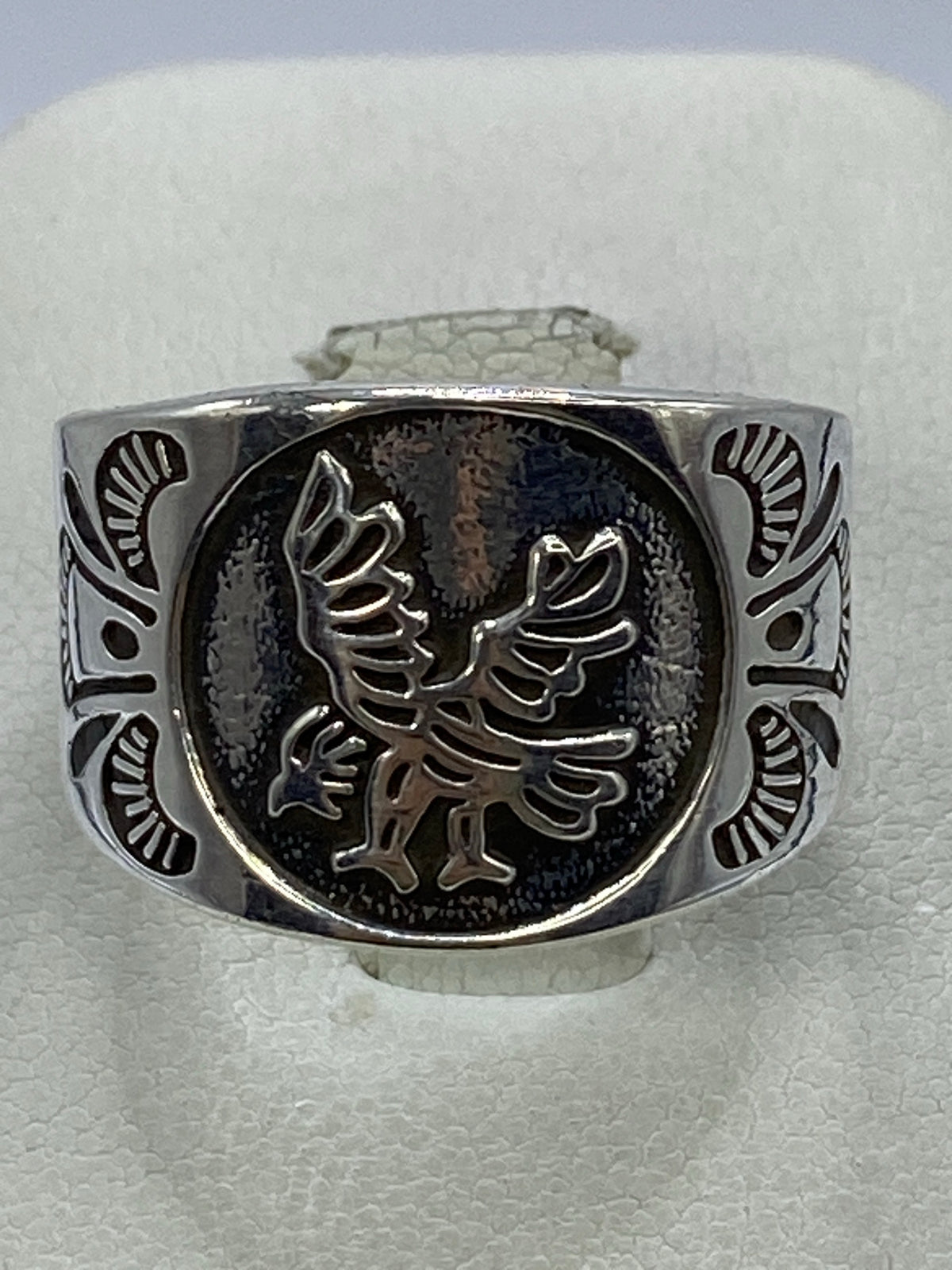 Anillo de plata 925 en repujado con águila heráldica en relieve, visto de frente