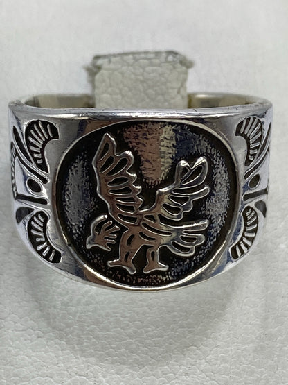 Anillo de plata repujado en la mano, mostrando la profundidad del diseño del águila