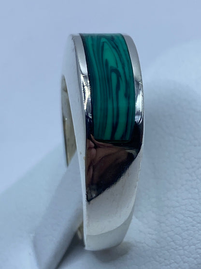 Anillo puesto en el dedo mostrando cómo luce la malaquita verde con la plata