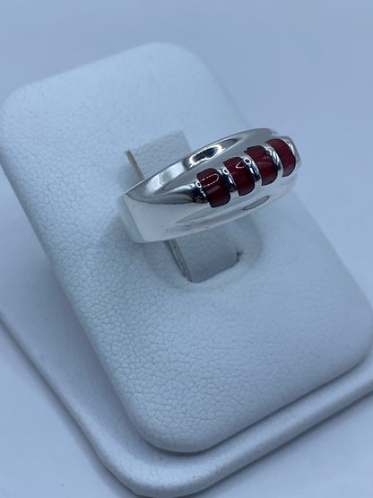 Anillo de plata con coral rojo colocado en dedo, mostrando el color intenso
