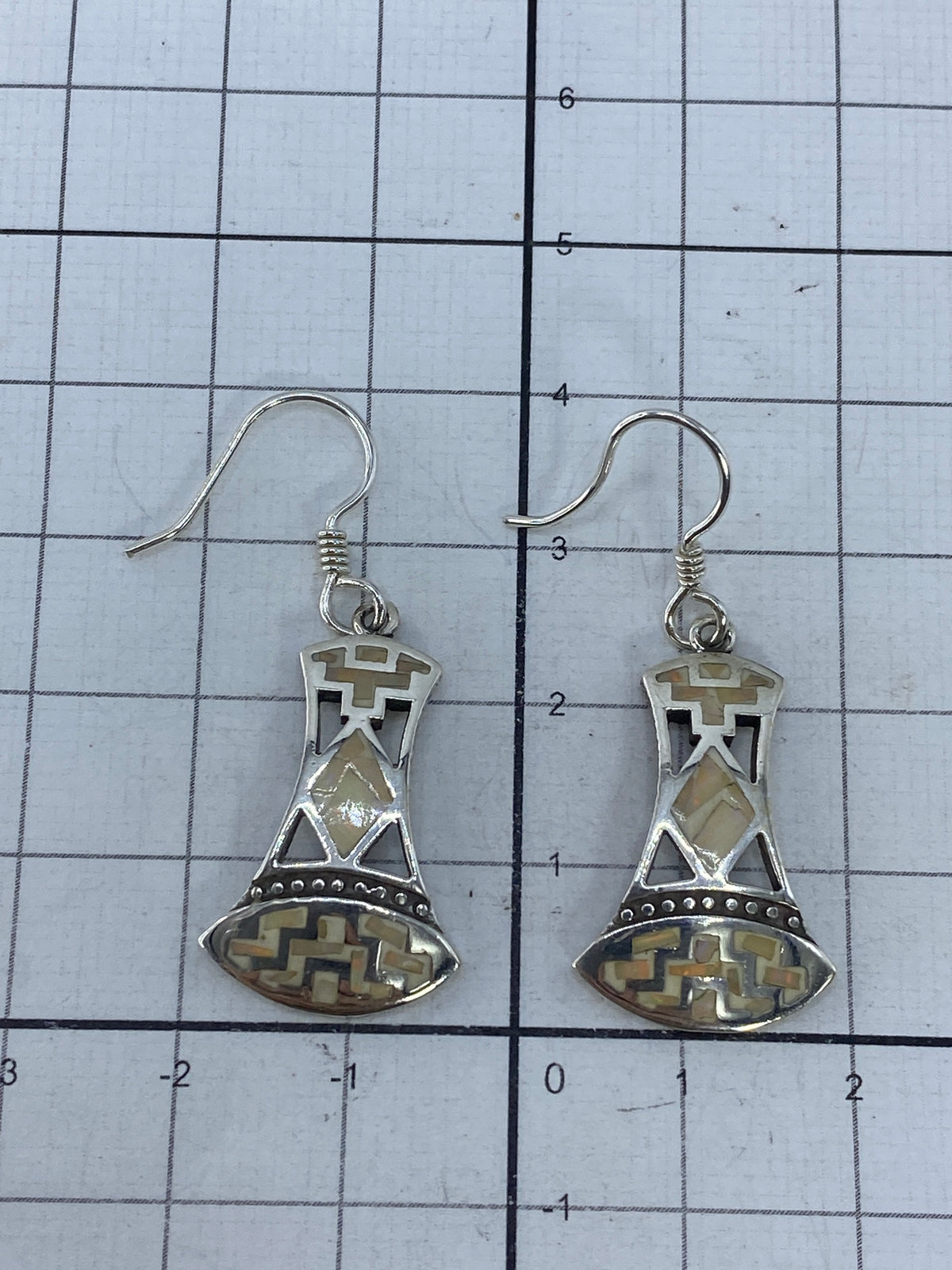 Aretes sobre fondo blanco con patrón de color del ópalo visible