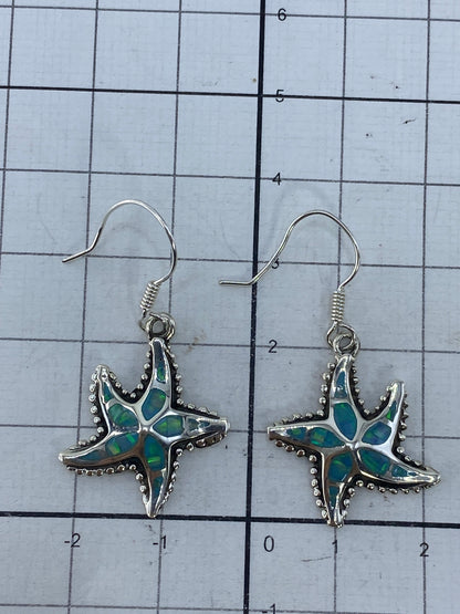Aretes sobre medidor de centímetros mostrando el largo de 3.7 cm