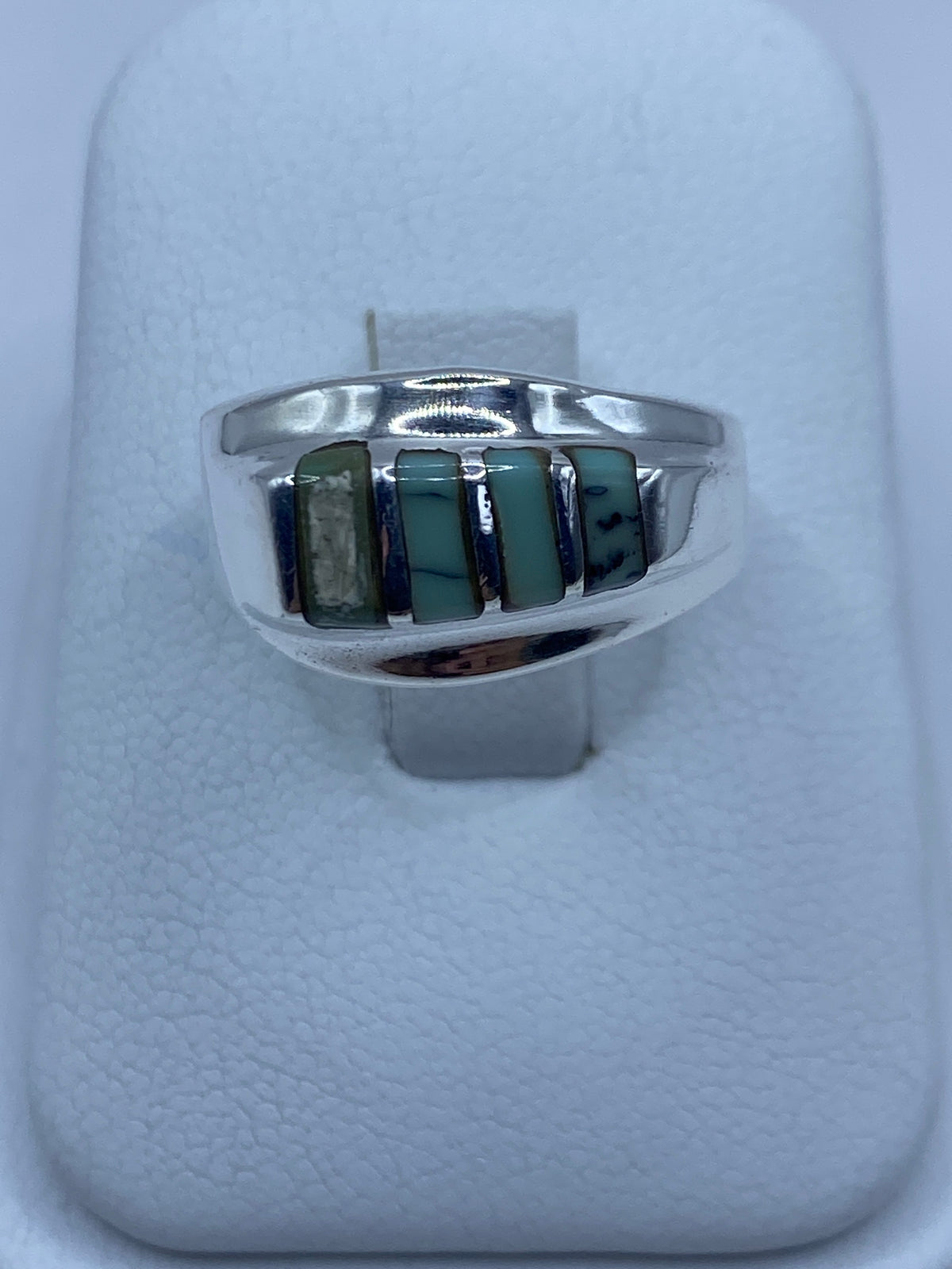 Anillo de plata con turquesa azul cielo engastada en la mano de una mujer