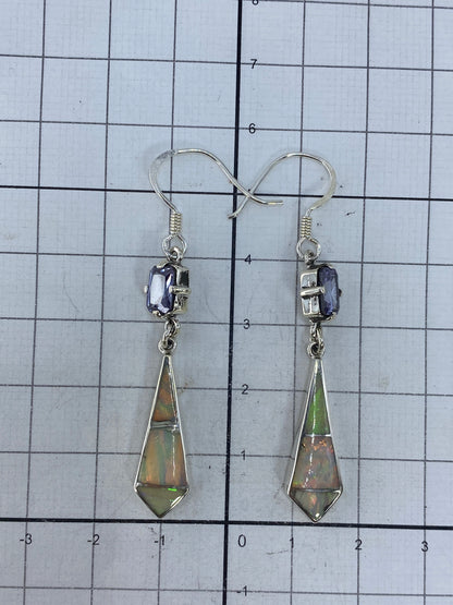 Aretes sobre regla de centímetros mostrando largo de 5.7 cm, con hallmark 950 visible