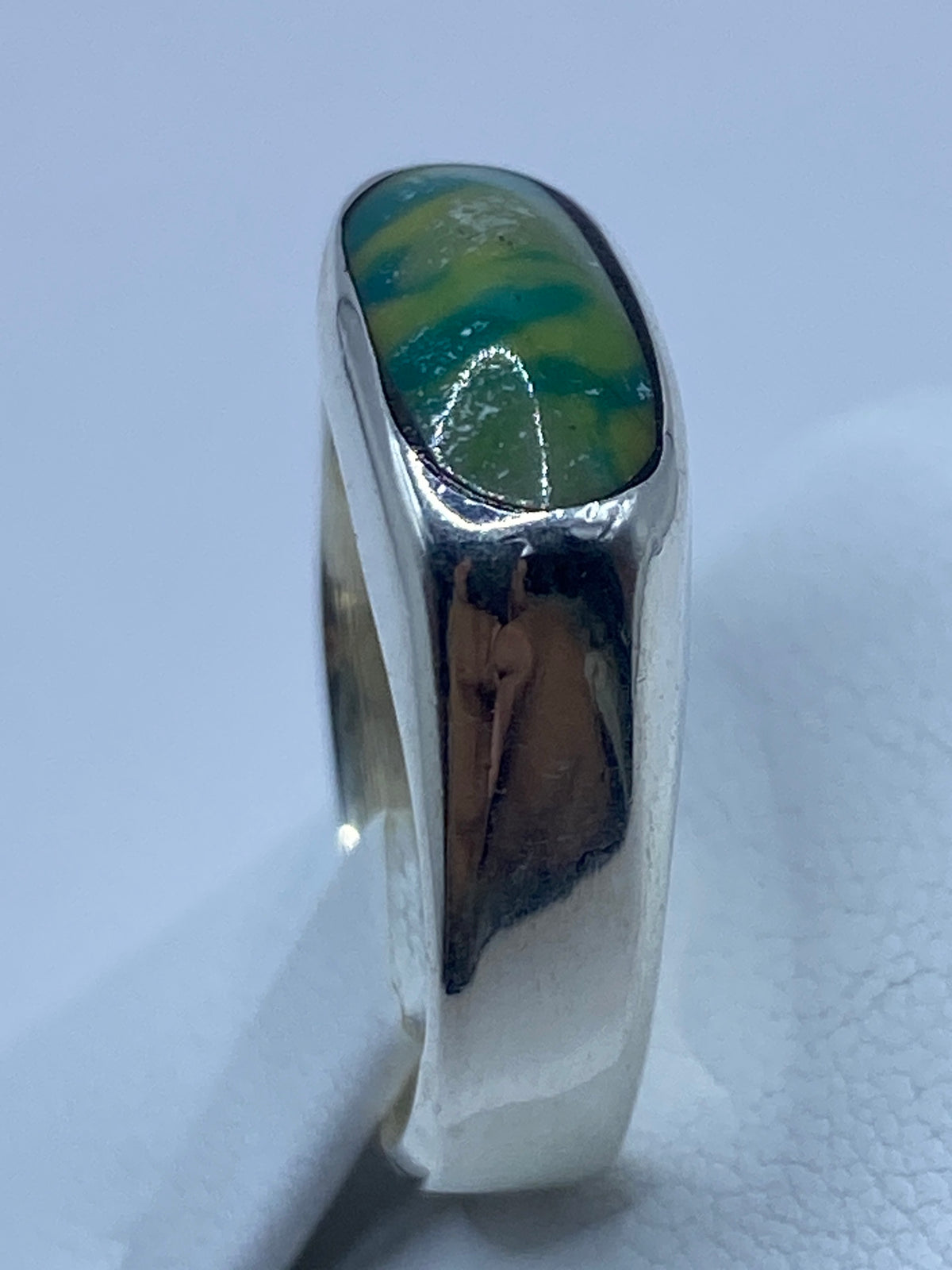 Anillo puesto en dedo mostrando el color natural multicolor de la turquesa africana