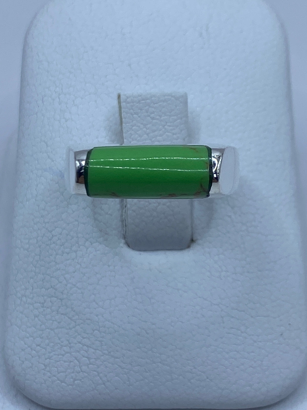 Anillo de plata 925 con piedra verde engastada en la mano de una persona