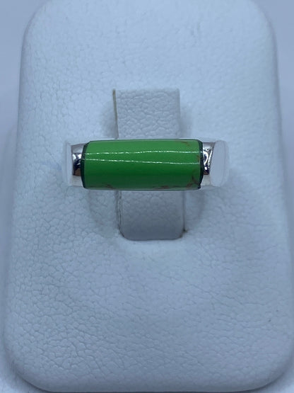 Anillo de plata 925 con piedra verde engastada en la mano de una persona