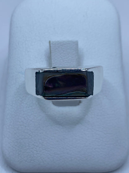 Anillo de plata 925 con concha de abulón iridiscente en la mano