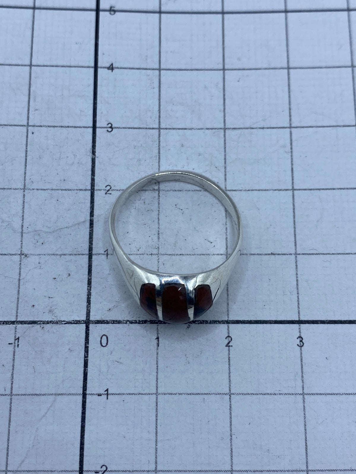 Anillo sobre banda de medición mostrando talla 7 y peso de 4.4 gramos
