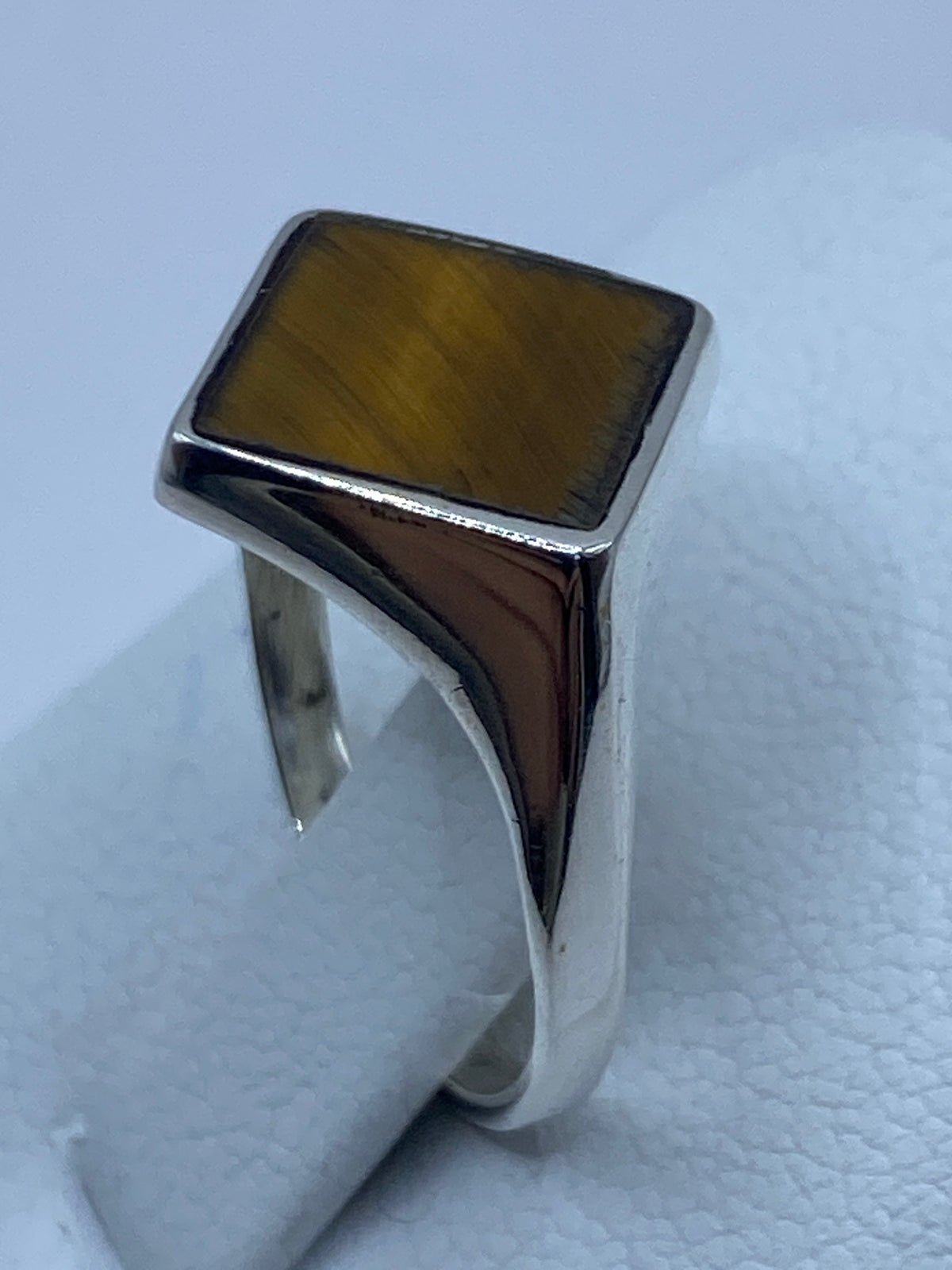 Vista lateral del anillo de plata con piedra café cálida