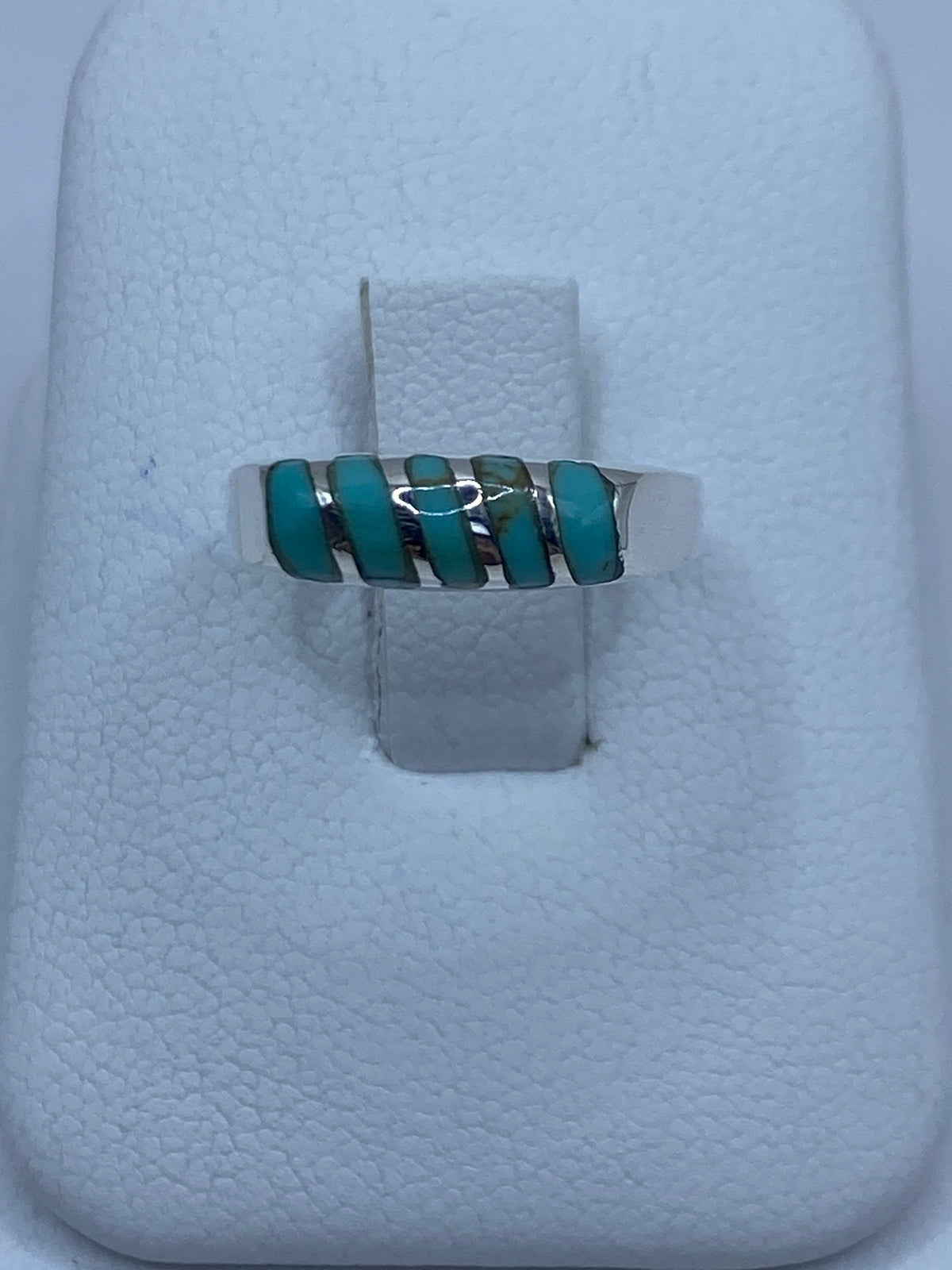 Anillo de plata con ópalo de fuego azul cielo engastado en la mano de una mujer