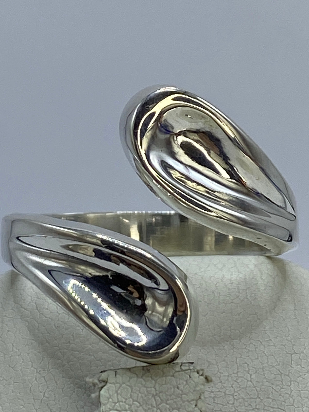 Anillo de plata ajustable con diseño fluido en plata 925 sobre fondo blanco