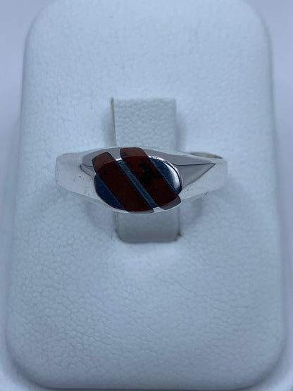 Anillo de plata con ojo de tigre café reposando en estuche blanco de presentación