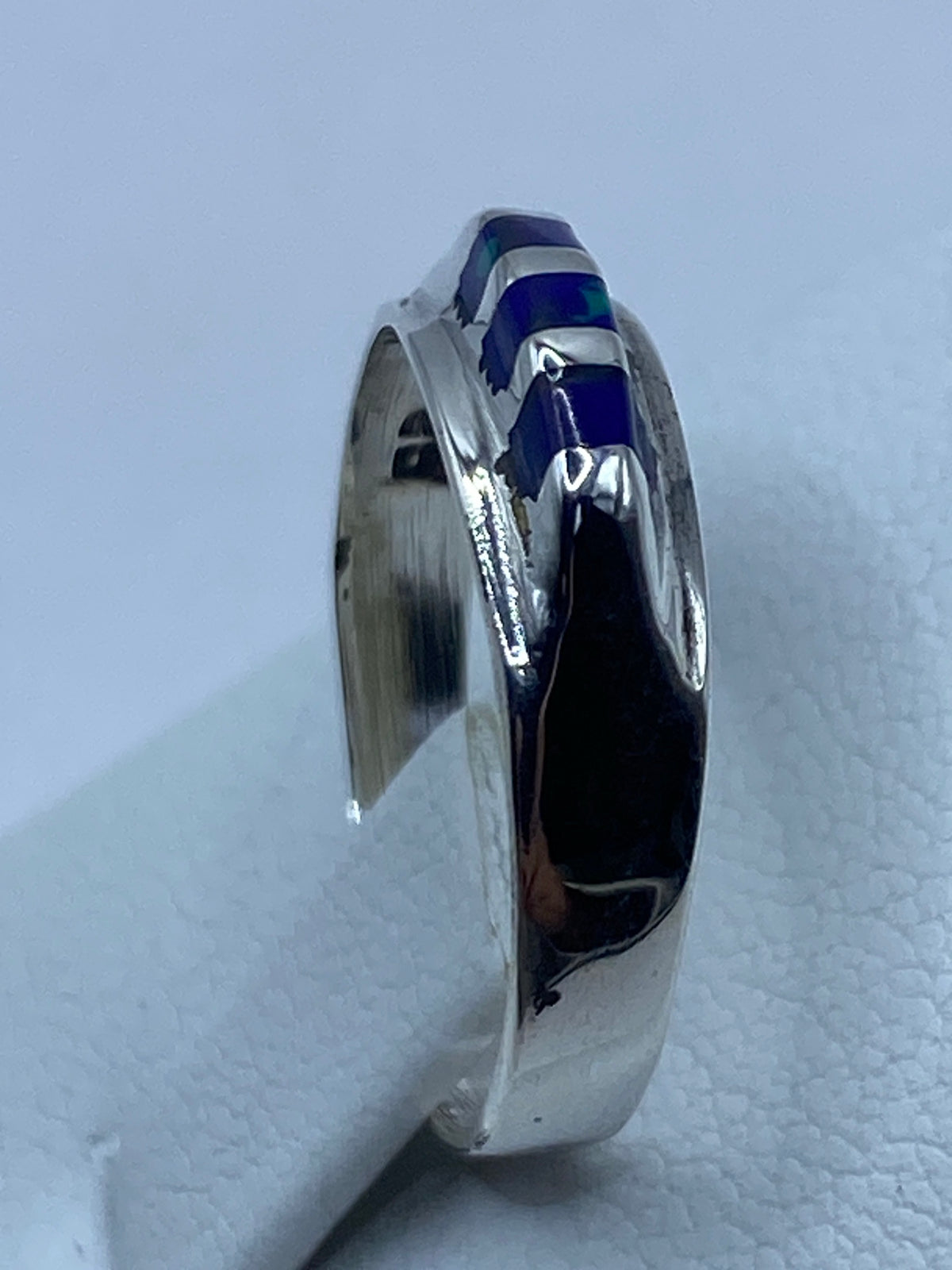 Anillo de plata puesto en dedo, piedra azul brillante