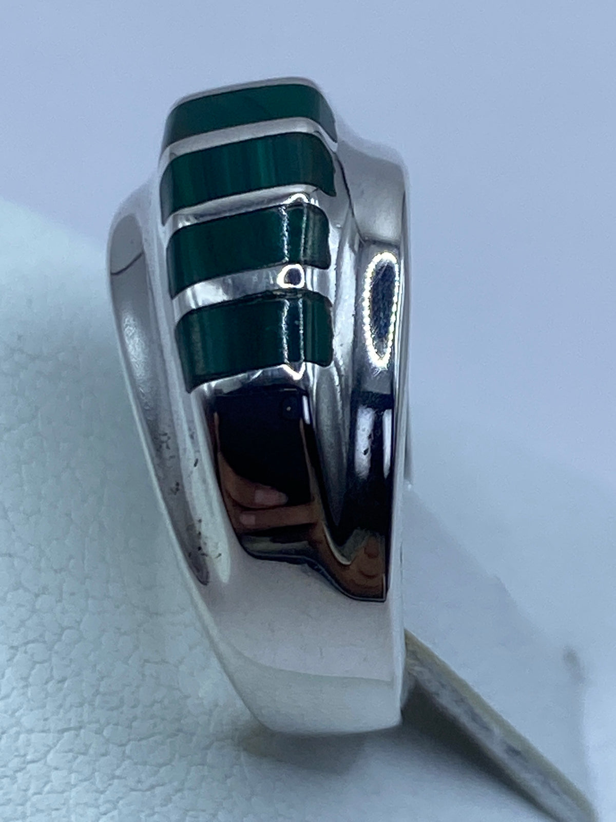 Detalle lateral del anillo mostrando el engaste a mano de la malaquita