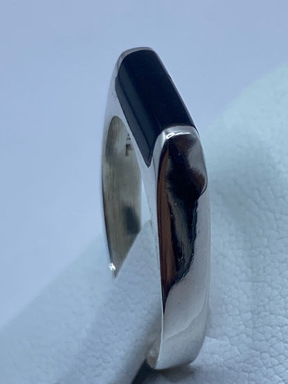Anillo de ónix en el dedo, mostrando el efecto del negro sobre plata brillante