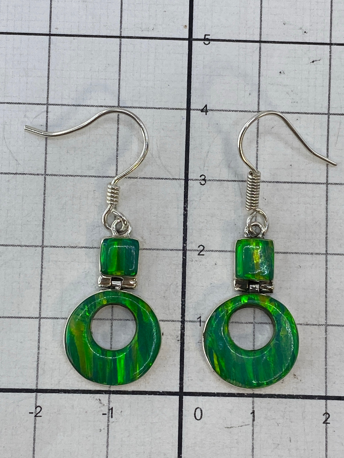 Aretes de ópalo de fuego sobre fondo blanco con marca de autenticidad 950