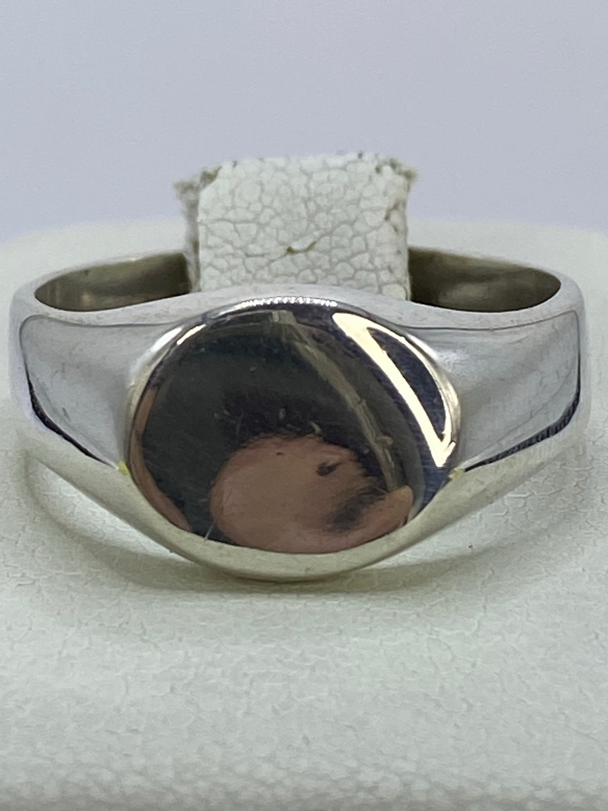 Anillo de plata cartoneado con volumen geométrico en la mano de una mujer
