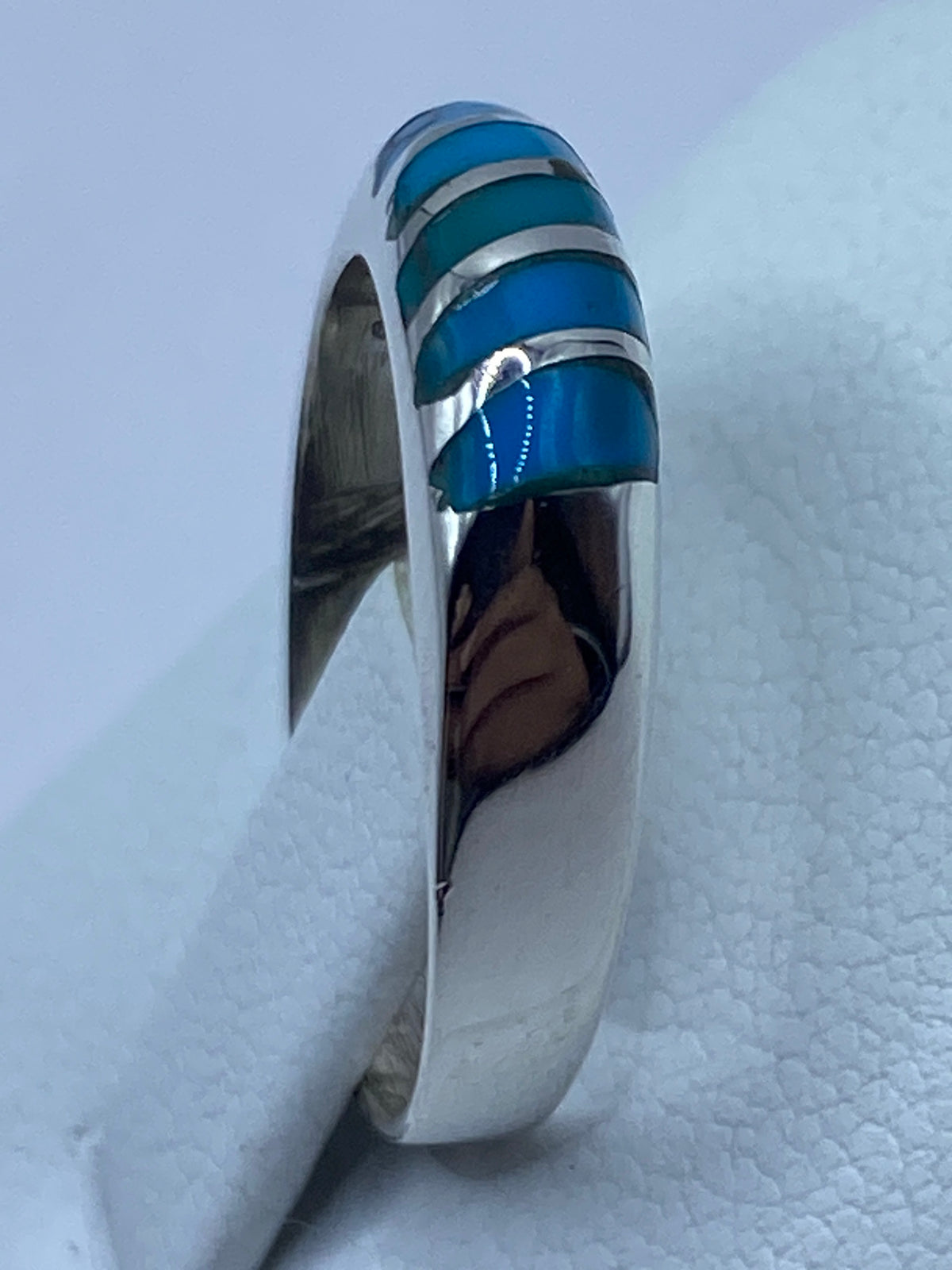 Anillo en la mano de una persona, turquesa brillando al luz