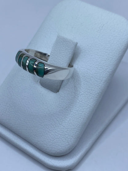 Vista de frente del anillo de turquesa en plata, mostrando el engaste artesanal