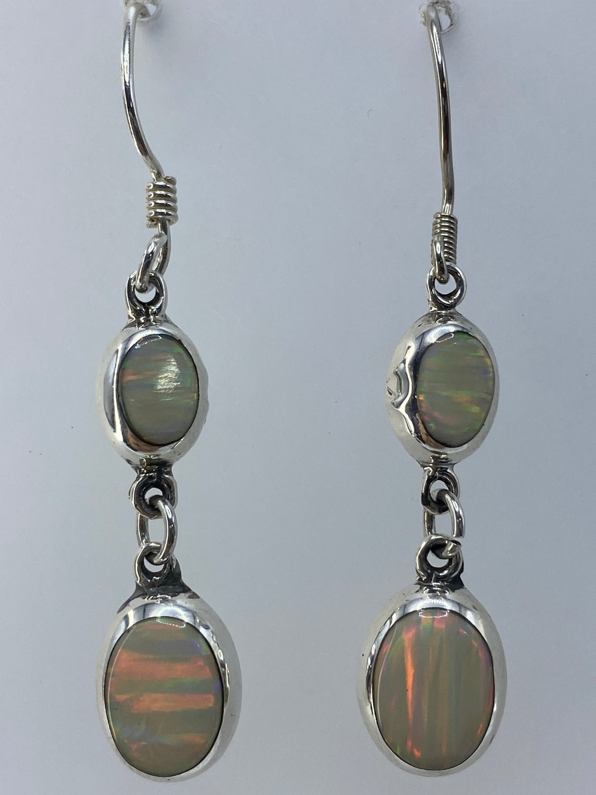 Par de aretes de ópalo de fuego al lado de escala de medida, largo 4.7 cm