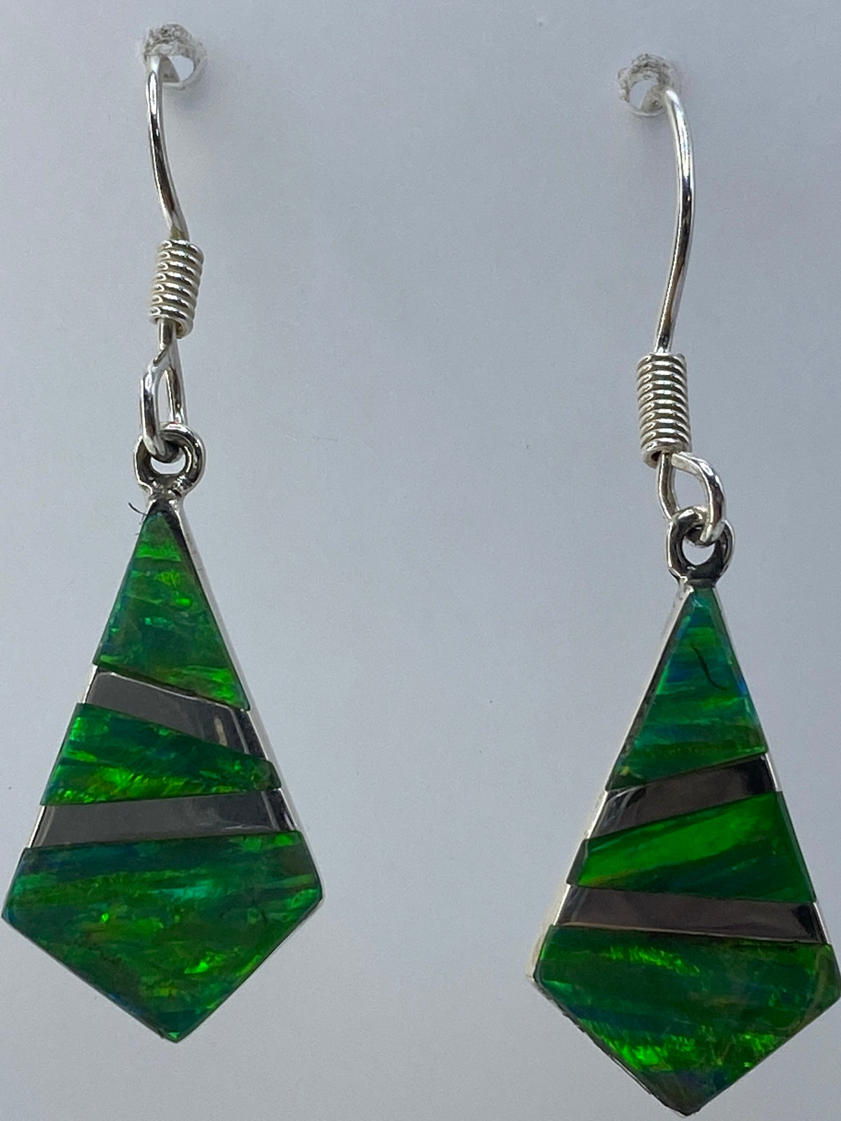 Aretes en la balanza mostrando 2.16 gramos, con el certificado de SKU visible