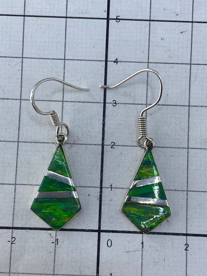 Aretes puestos en oreja, mostrando el largo de 3.5 cm y el brillo del ópalo verde limón