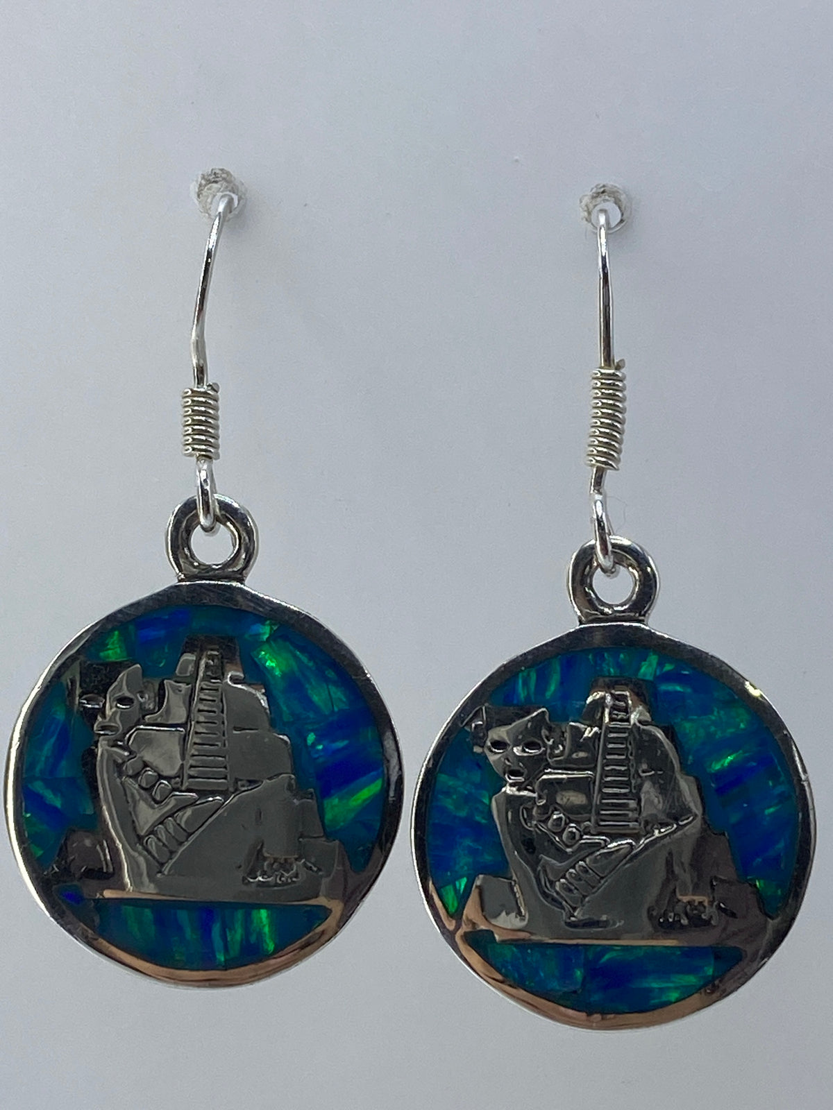 Detalle del ópalo de fuego verde limón en aretes de plata 950, mostrando el efecto de luz interna