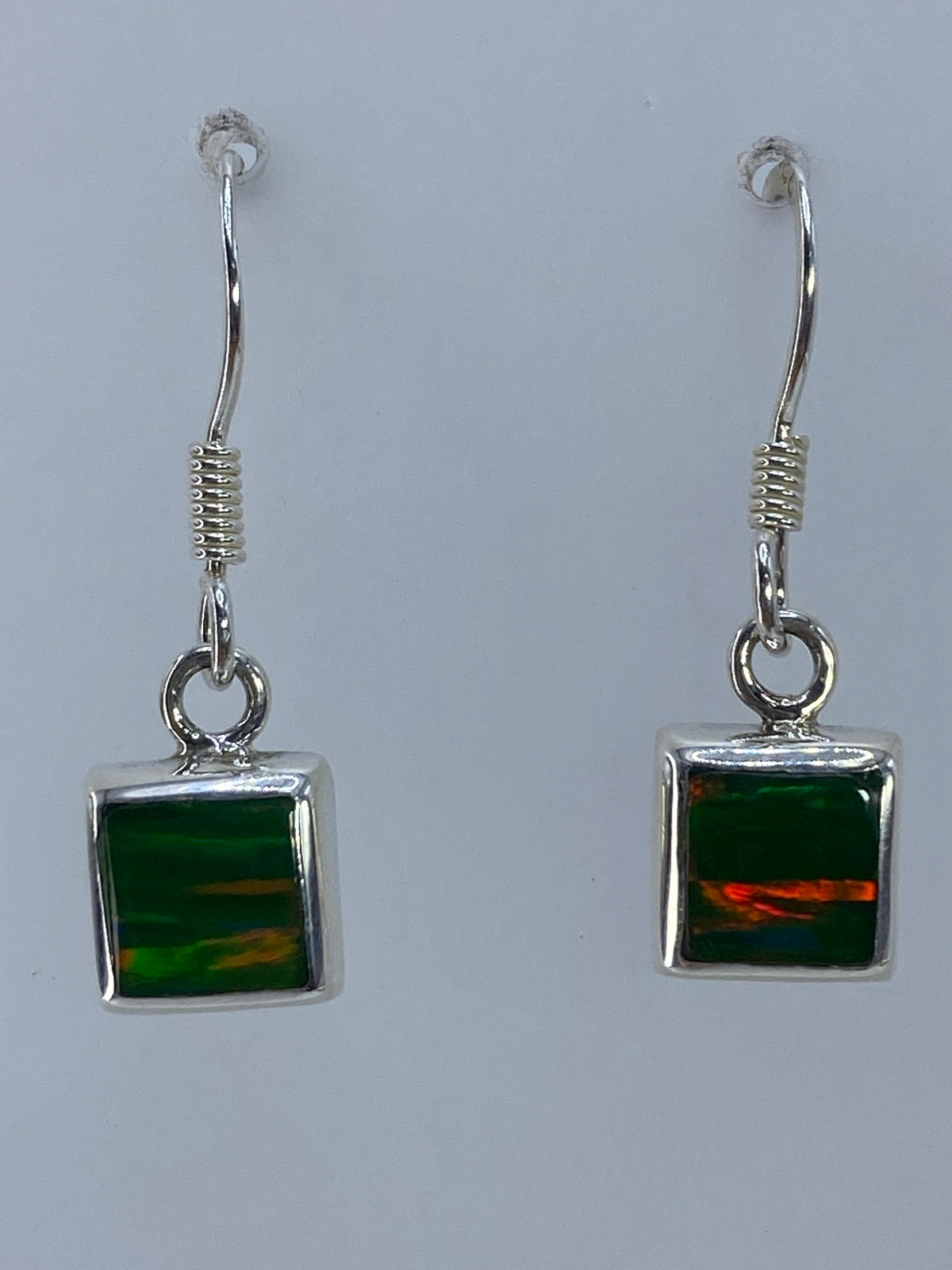 Par de aretes de plata con ópalo de fuego multicolor, visto de frente
