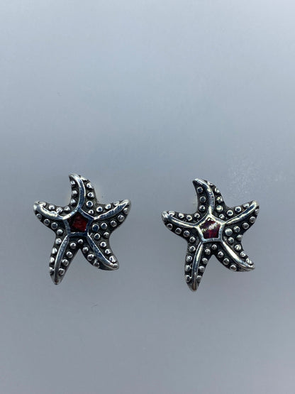 Par de aretes de plata con ópalo de fuego rojo engastado, sobre fondo gris