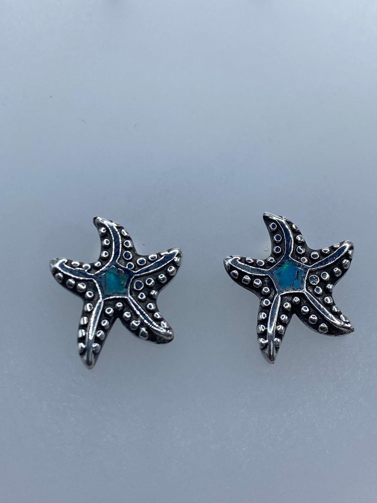 Detalle del engaste a mano de ópalo azul en el centro de la estrella