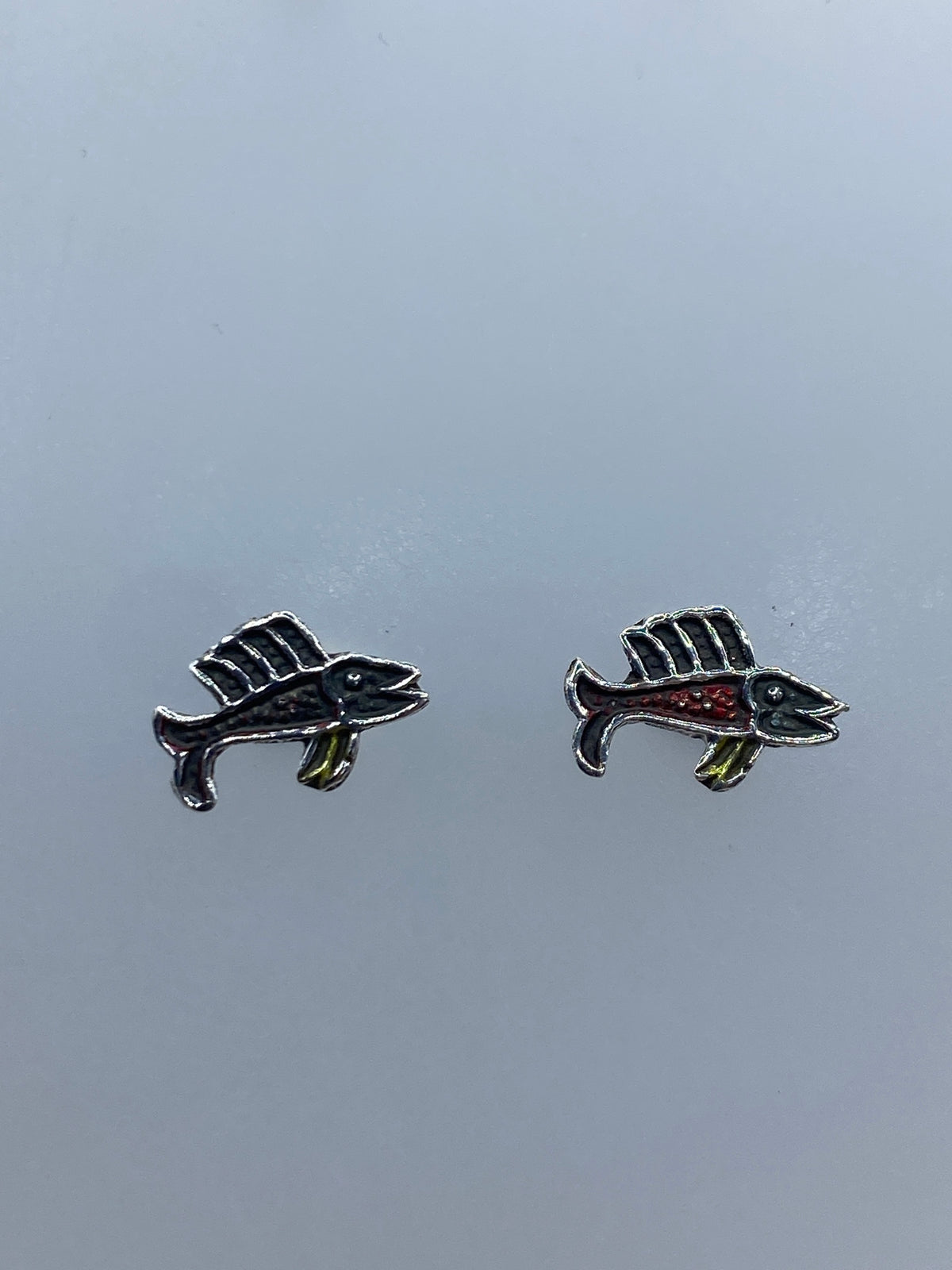 Par de aretes de plata repujada con forma de pez vela en miniatura