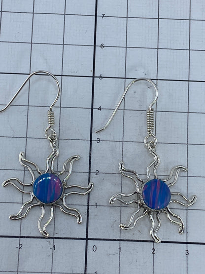 Aretes de ópalo de fuego colocados sobre superficie blanca, midiendo 5 cm de largo del par