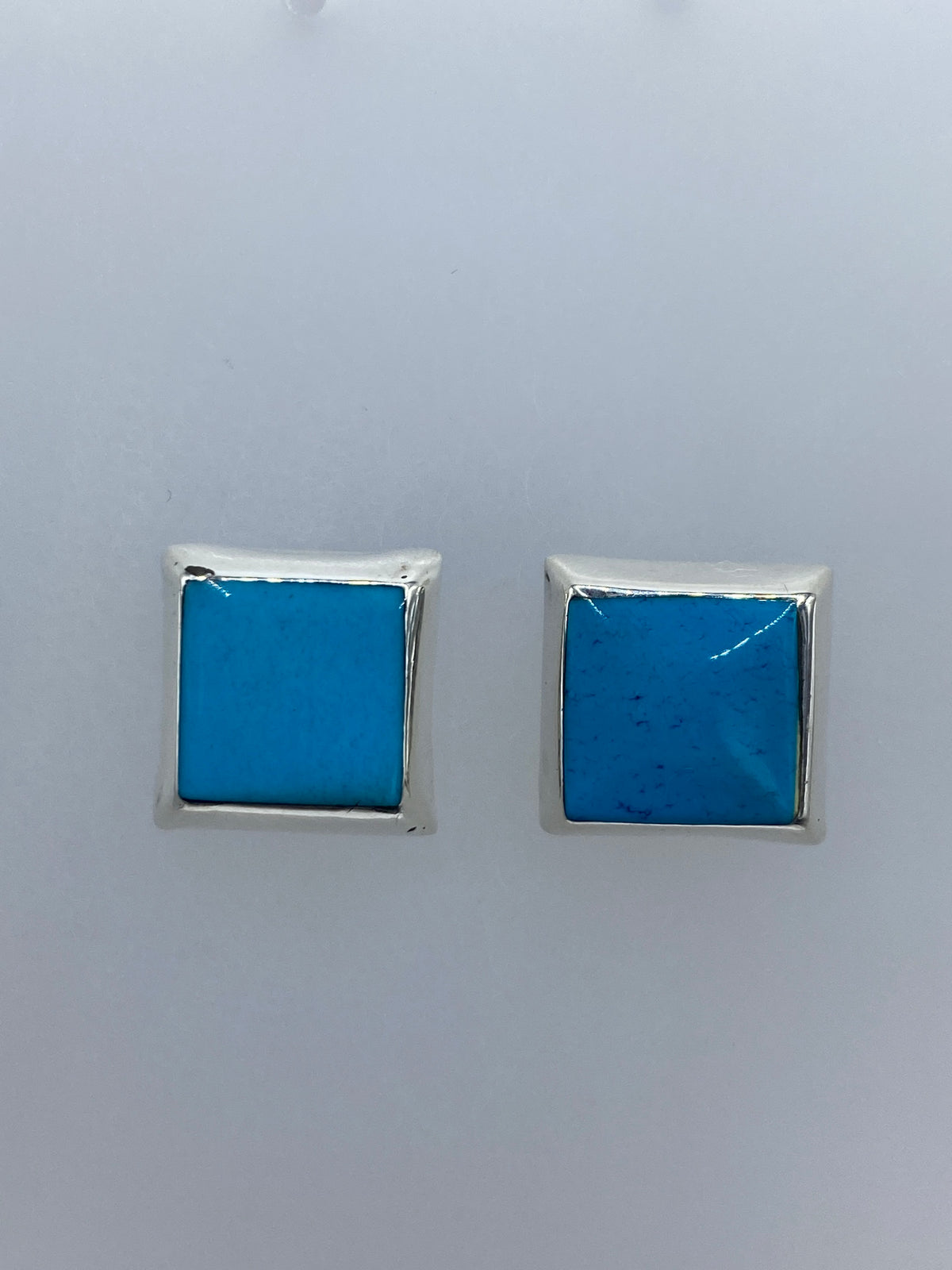 Aretes sobre regla de medida, mostrando tamaño de 1.3 × 1.3 cm