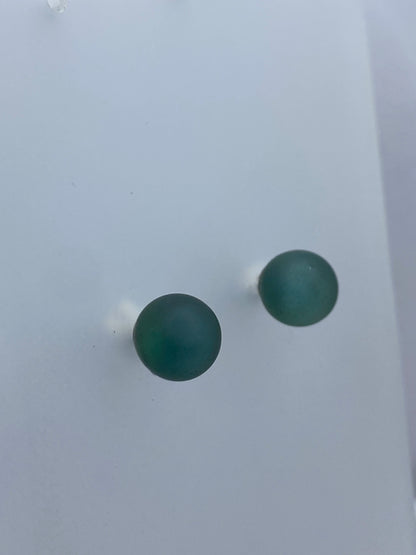 Aretes minimalistas en plata sobre escala de medición mostrando tamaño de 1.9 cm