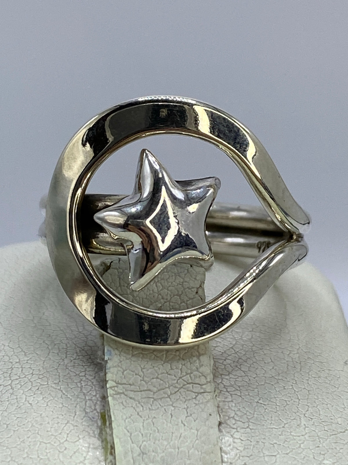 Anillo de plata calado con estrella geométrica en marco circular, vista frontal