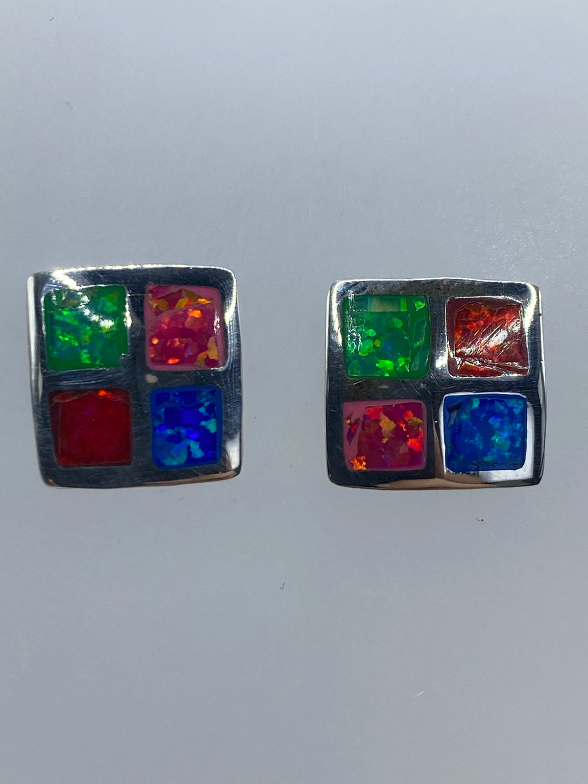 Aretes sobre medidor de precisión mostrando tamaño de 1.2 cm × 1.2 cm
