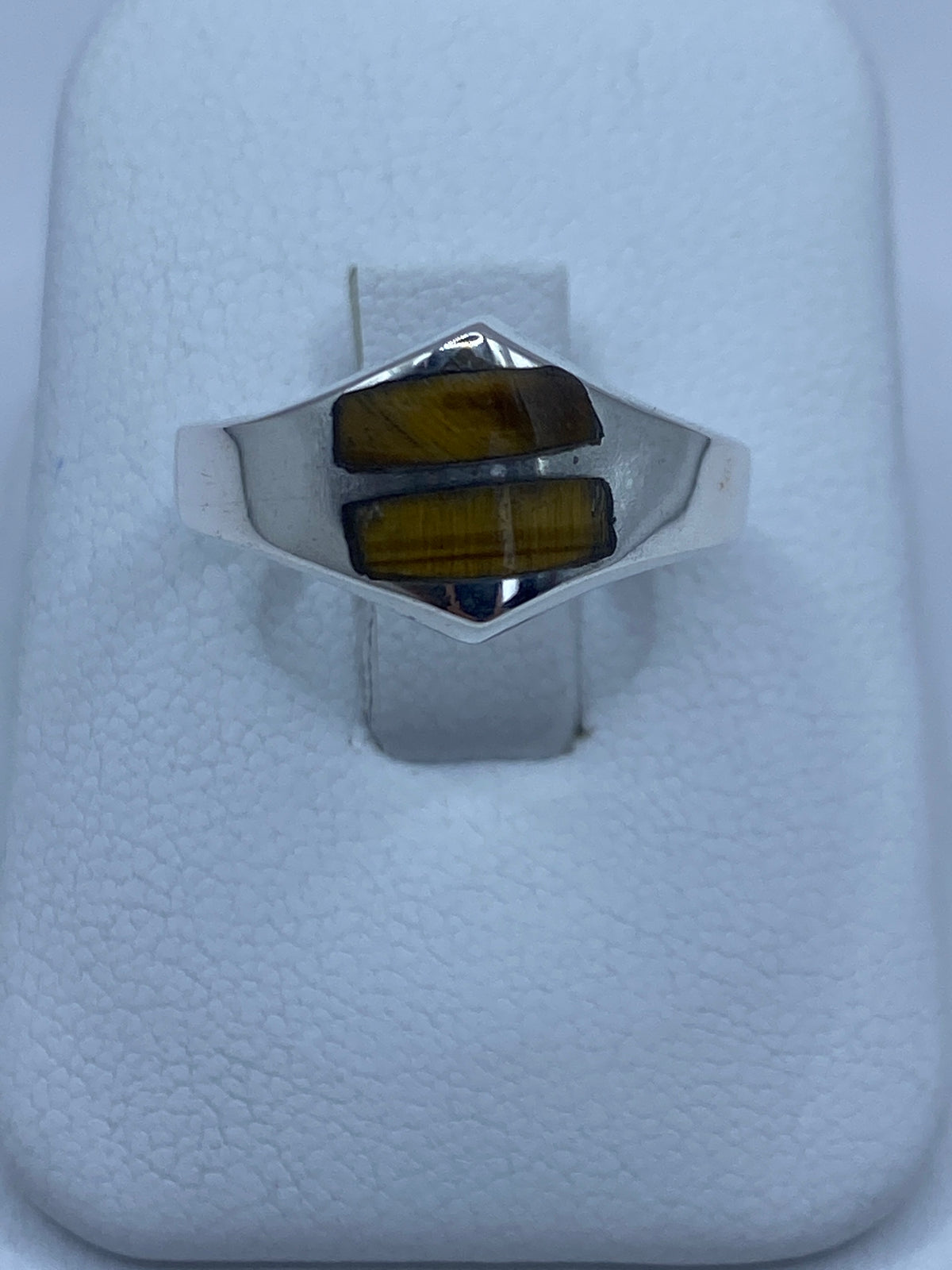 Anillo de plata 925 con ojo de tigre café en la mano de una persona