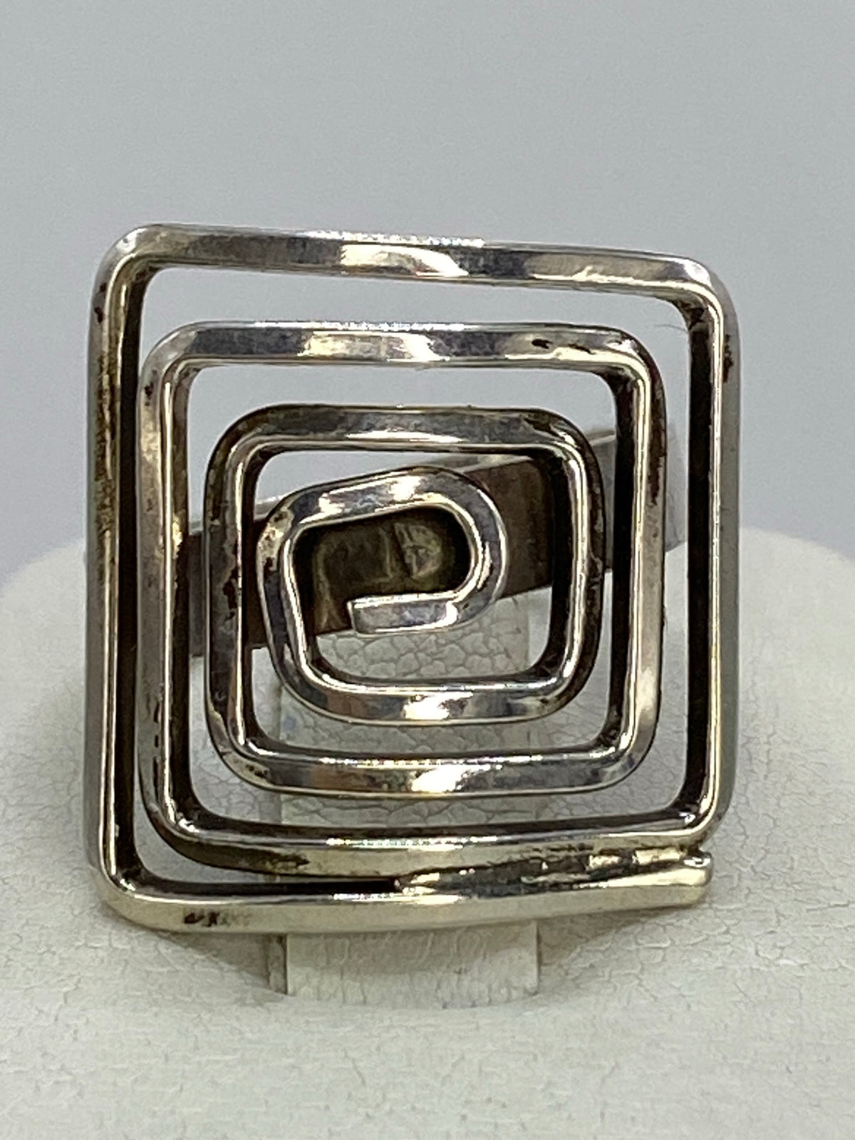 Anillo de plata 925 en calado con volúmenes en espiral, visto desde arriba en la mano