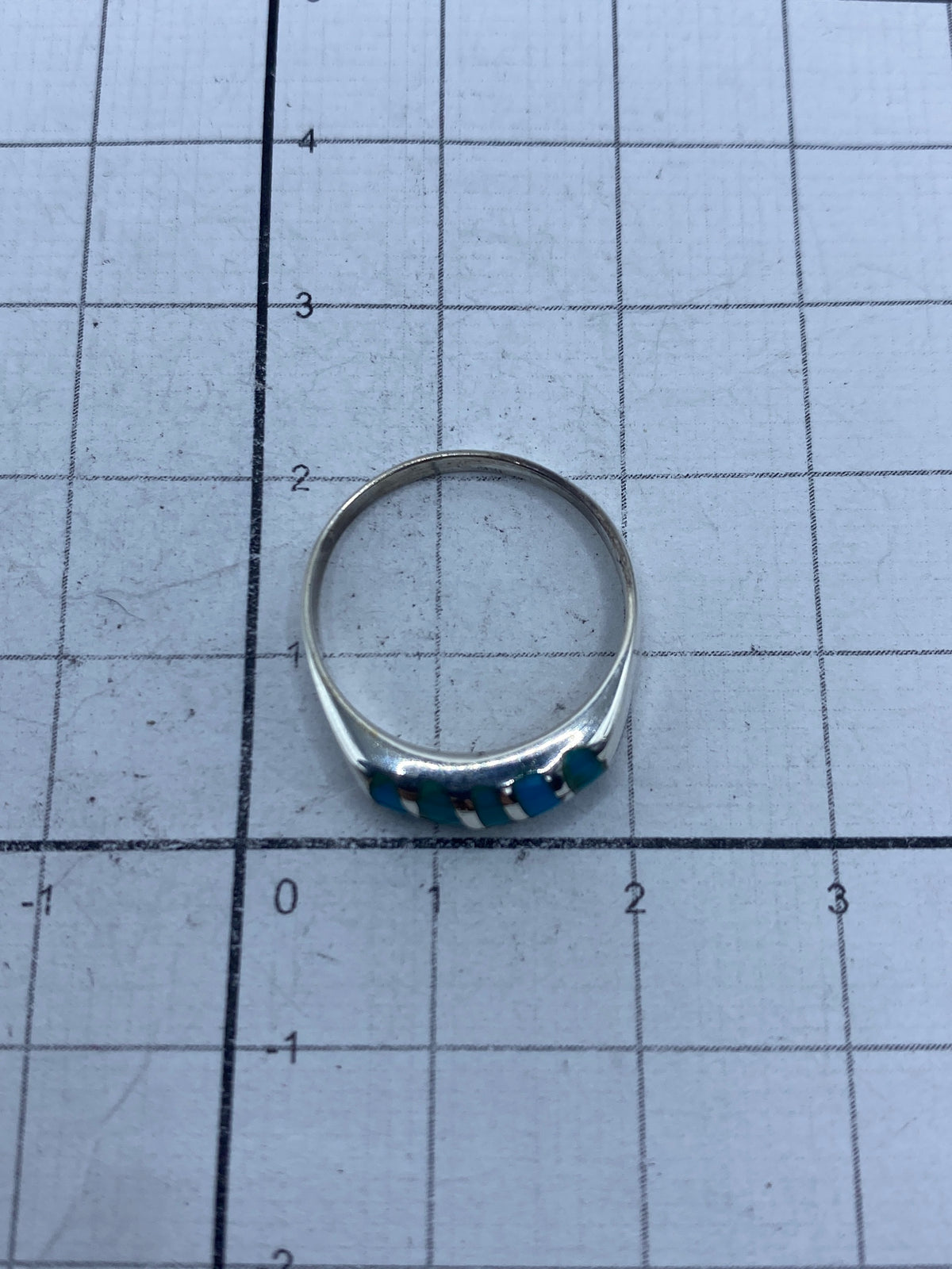Anillo sobre fondo blanco con marca de peso 2.3 gramos