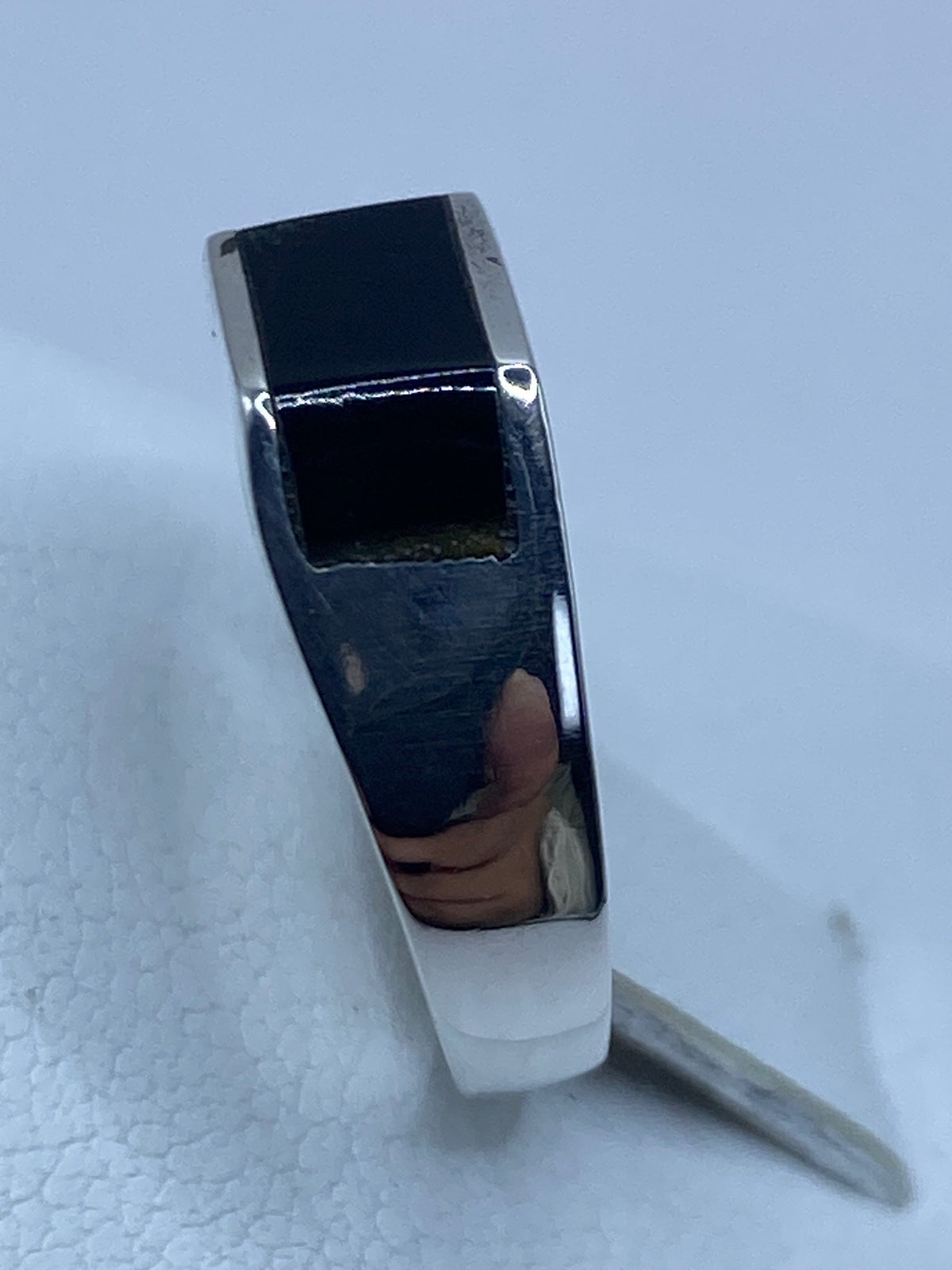 Anillo puesto en dedo mostrando el contraste del ónix negro con el brillo de la plata