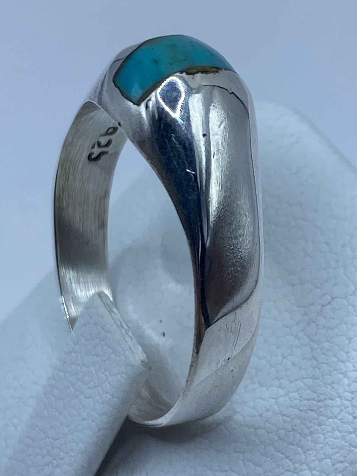 Detalle del engaste de turquesa azul en plata pulida