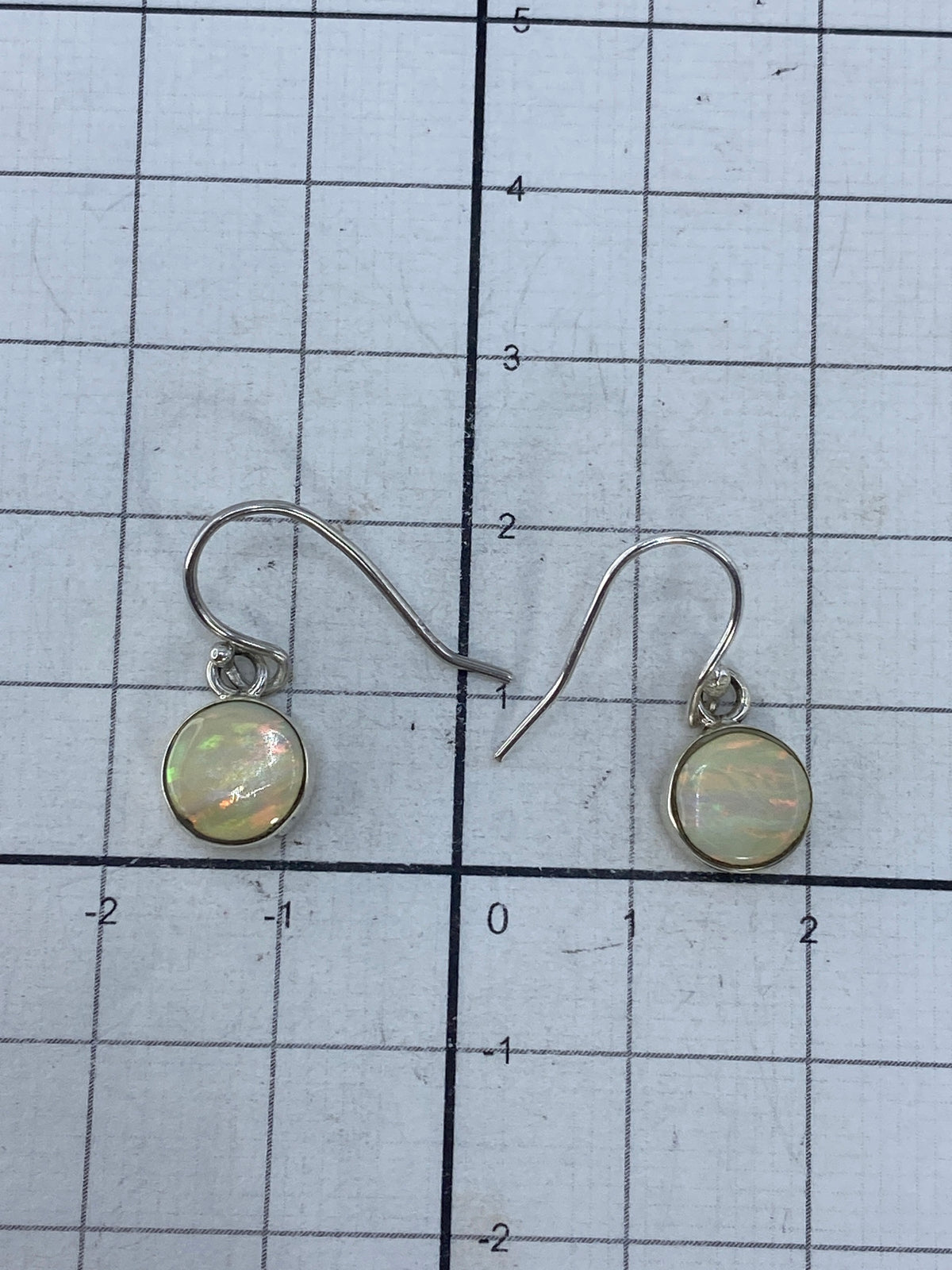 Aretes sobre fondo blanco con el sello 950 de plata pura visible