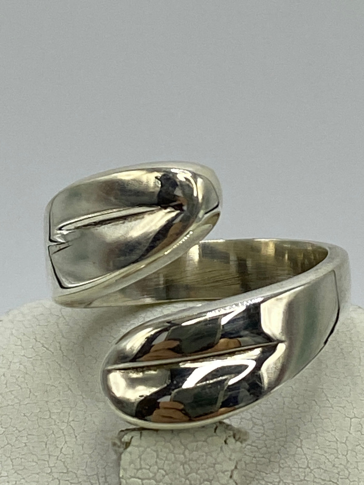 Anillo de plata 925 con cartoneado en volumen 3D, visto desde arriba sobre fondo gris