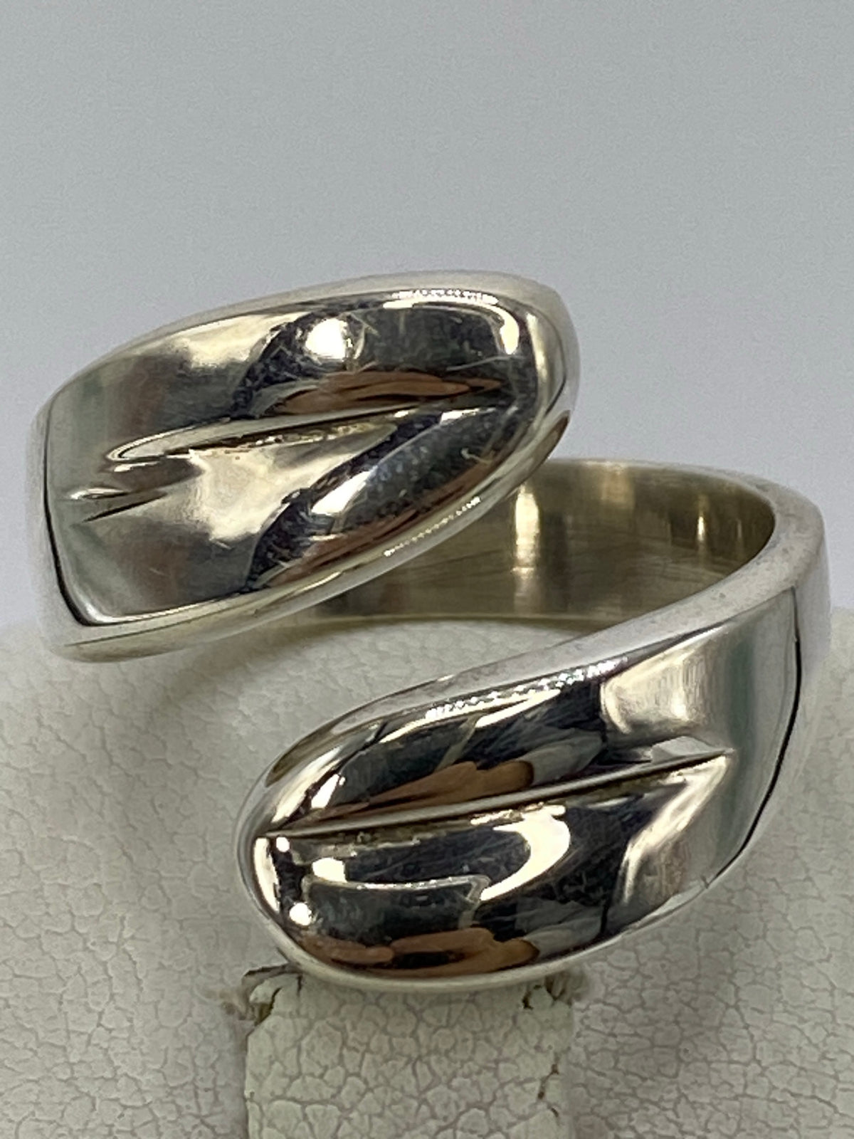 Anillo de plata en la mano de una mujer, evidenciando el cartoneado brillante