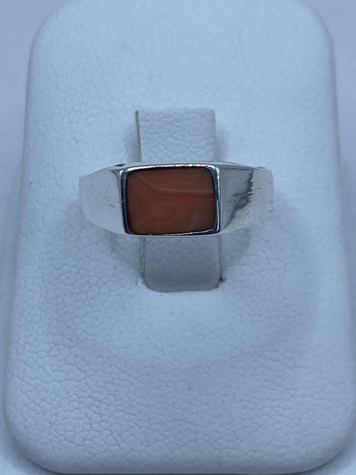 Anillo de plata 925 con coral engastado en la mano de una mujer