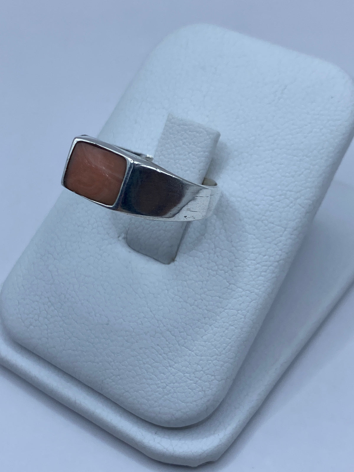 Vista frontal del anillo de plata con coral — tonalidad cálida