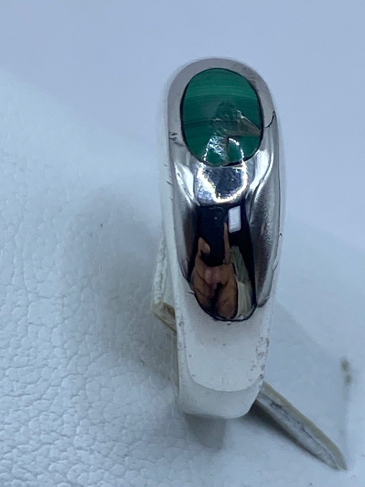 Anillo de malaquita puesto en el dedo, demostrando el brillo y profundidad del verde