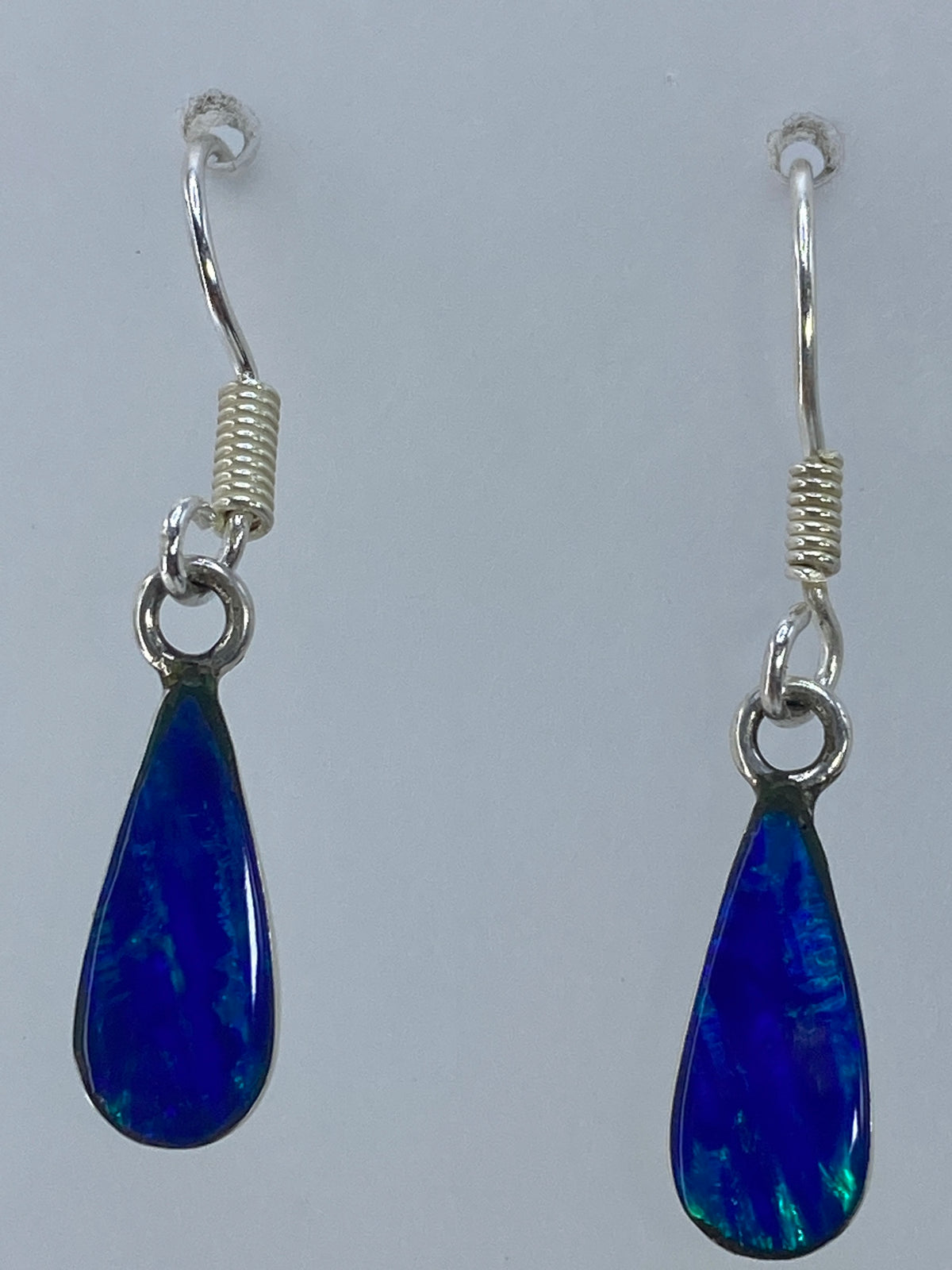 Aretes puestos en la oreja, largos y elegantes, color verde olivo